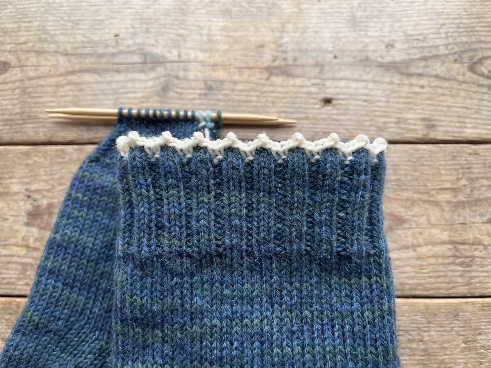Dehnbare Zacken-Anschlagkante am Bündchen eines Strickstücks auf der Nadel.