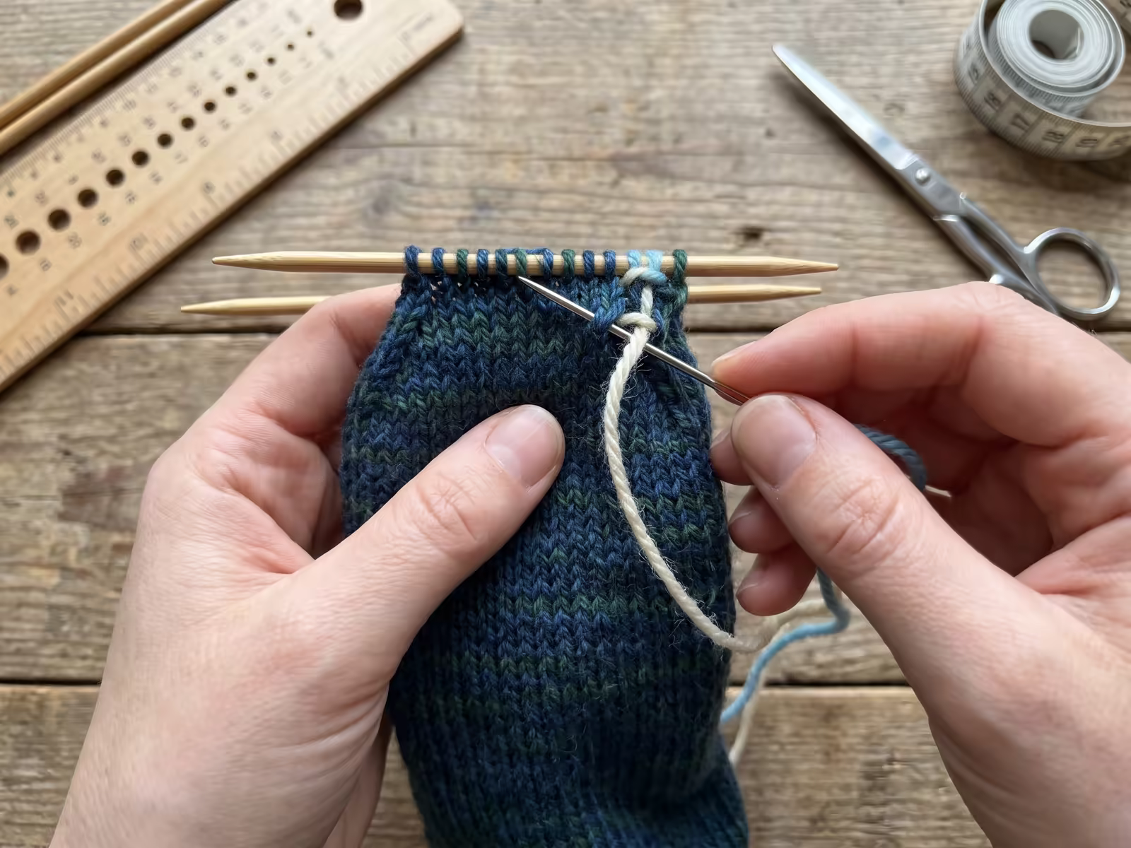 Eine Sockenspitze wird mit dem Maschenstich (Kitchener Stitch) und einer Nähnadel unsichtbar geschlossen.