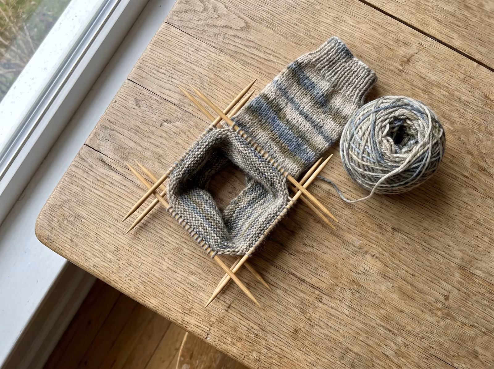 Socke auf einem Nadelspiel aus fünf Nadeln im Quadrat