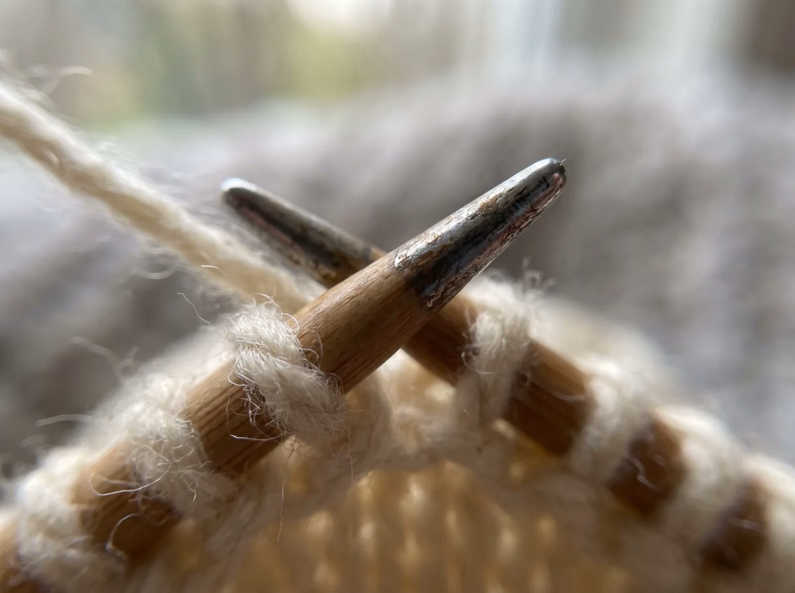 Rechte Nadel sticht von vorn in die Masche, der Faden liegt hinten